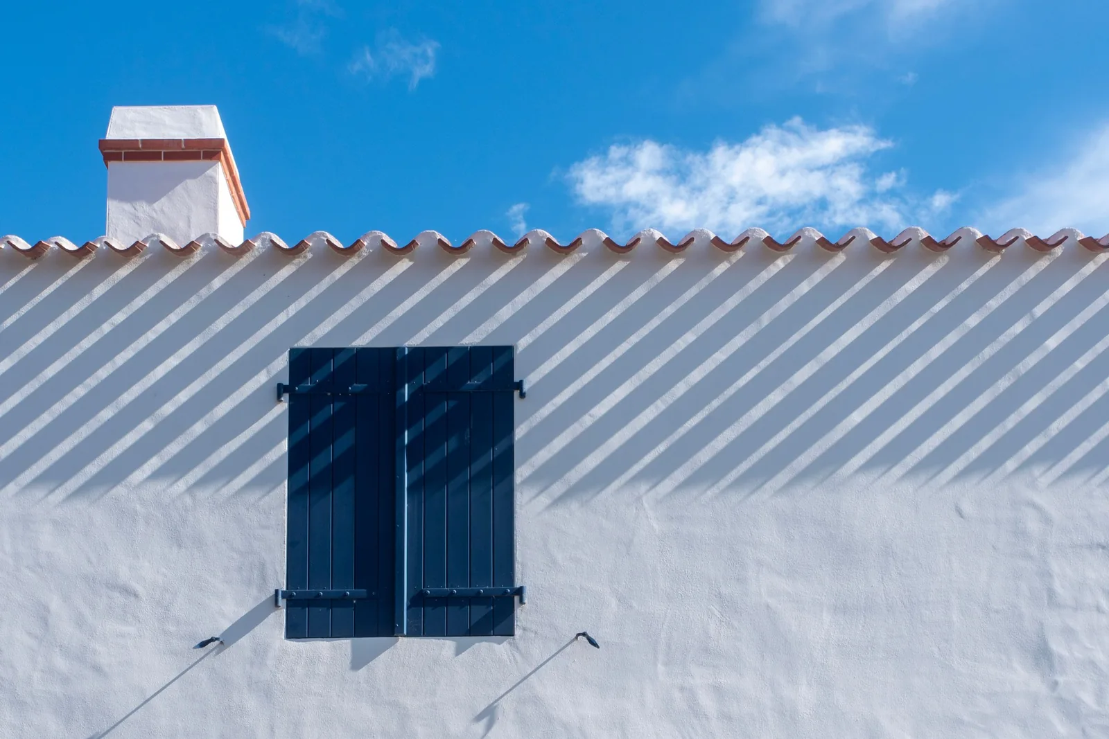 A shutter on a white facade