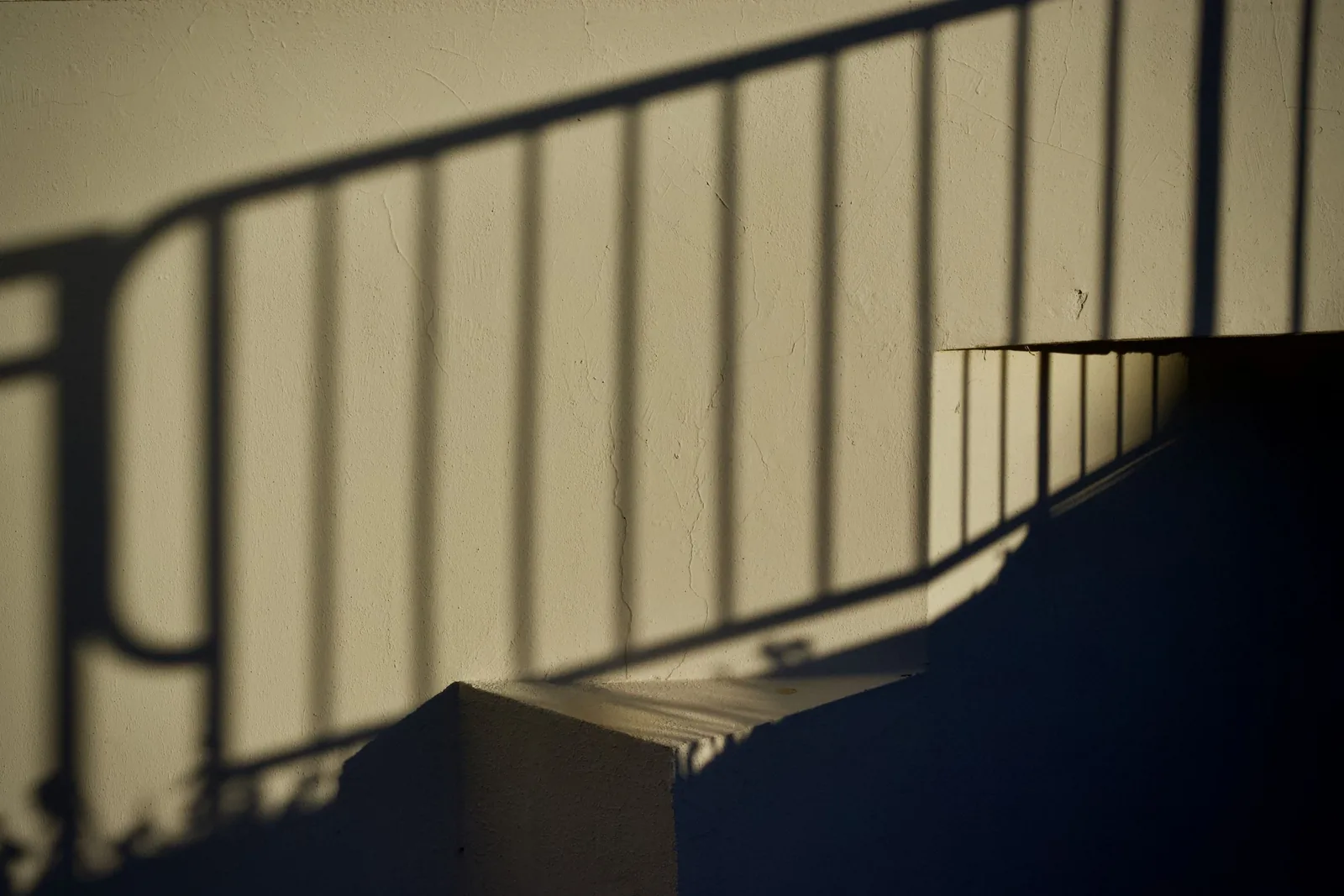 Shadow of a railing on a warm wall