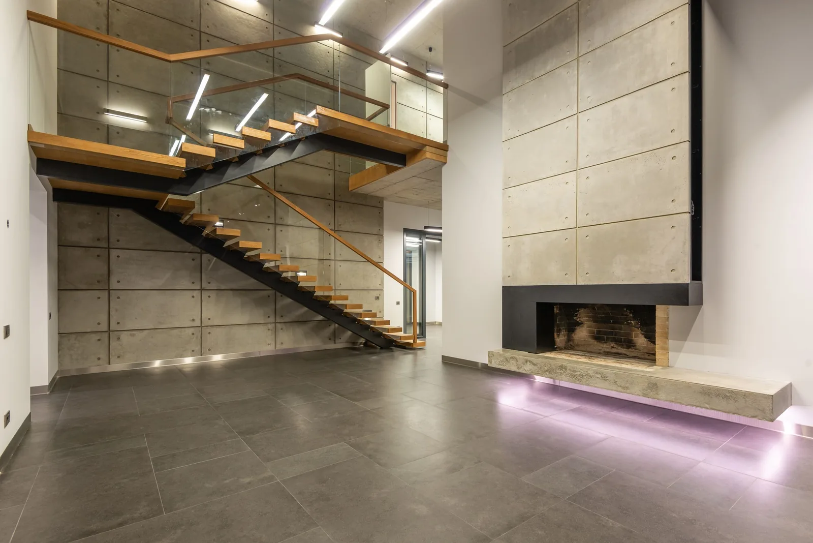 Open loft with timber stairs and a concrete wall